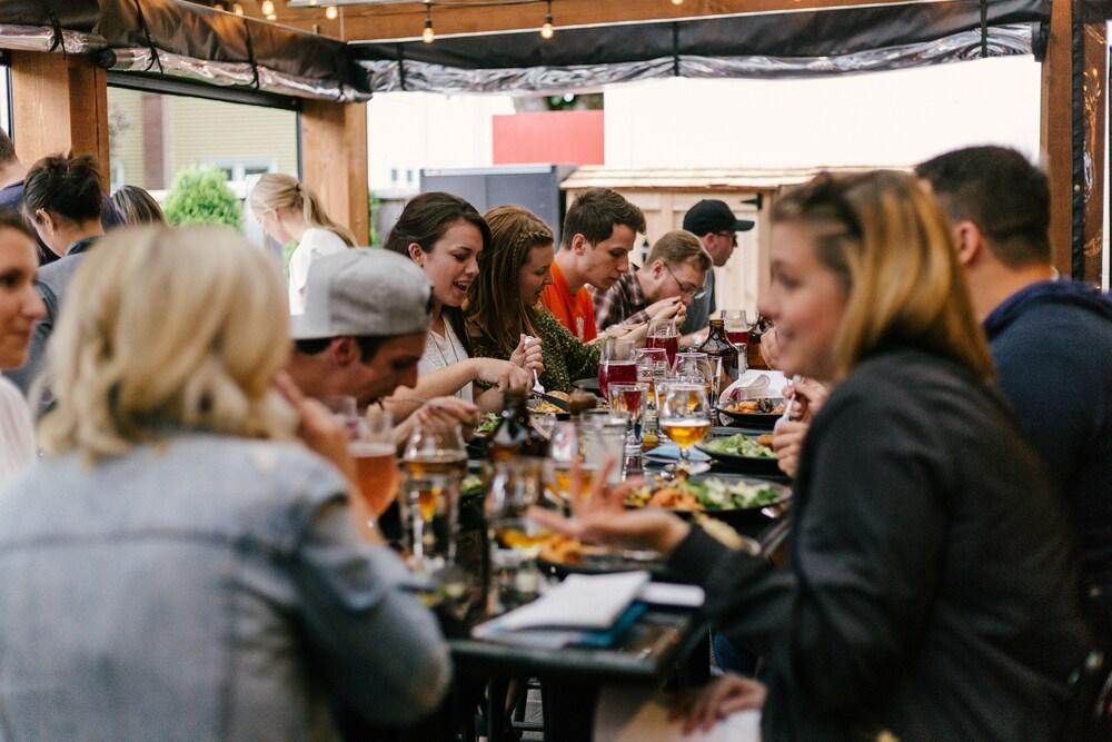 Group of Belgian people eating together with beers on the table.