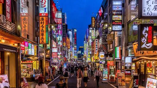 Busy Japanese street with many ads, colorful, and few people.