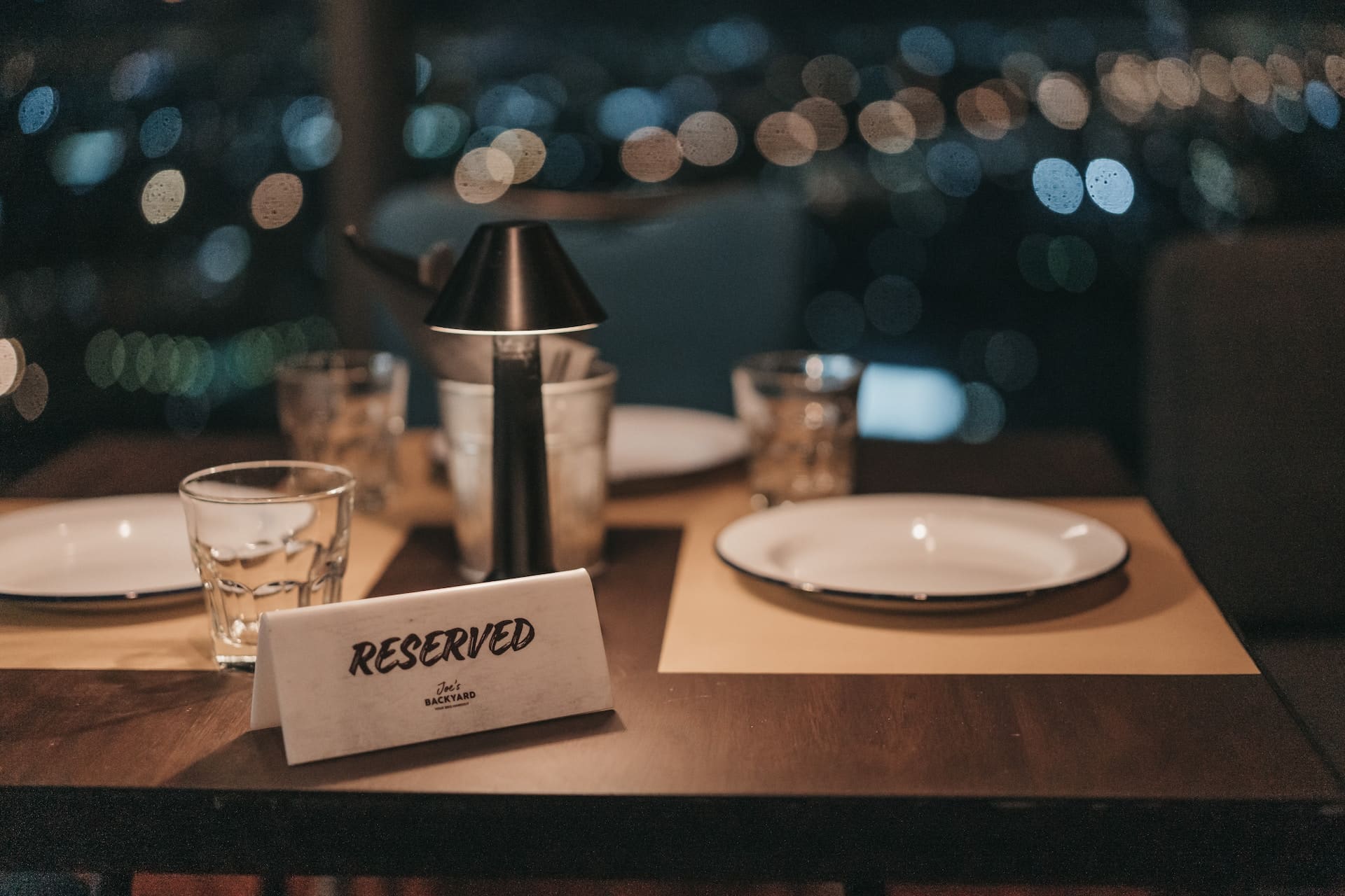 Empty table with plates and a sign reserved